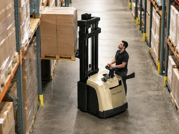 Akuros electric stacker truck lifting a pallet in a warehouse aisle