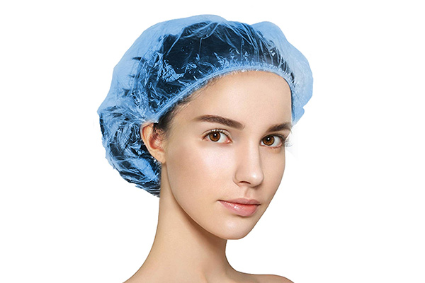 How do you put on a disposable surgical cap?